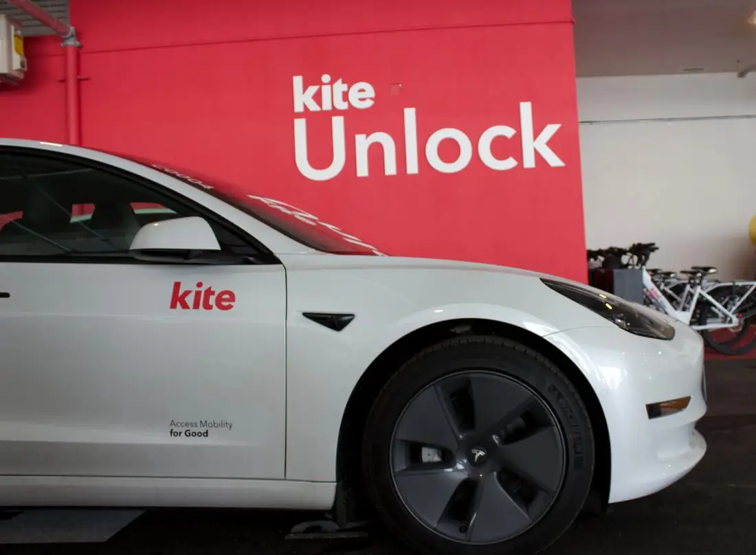 A Kite car parked at the MRKT Alexandra Park hub by the Kite Unlock wall